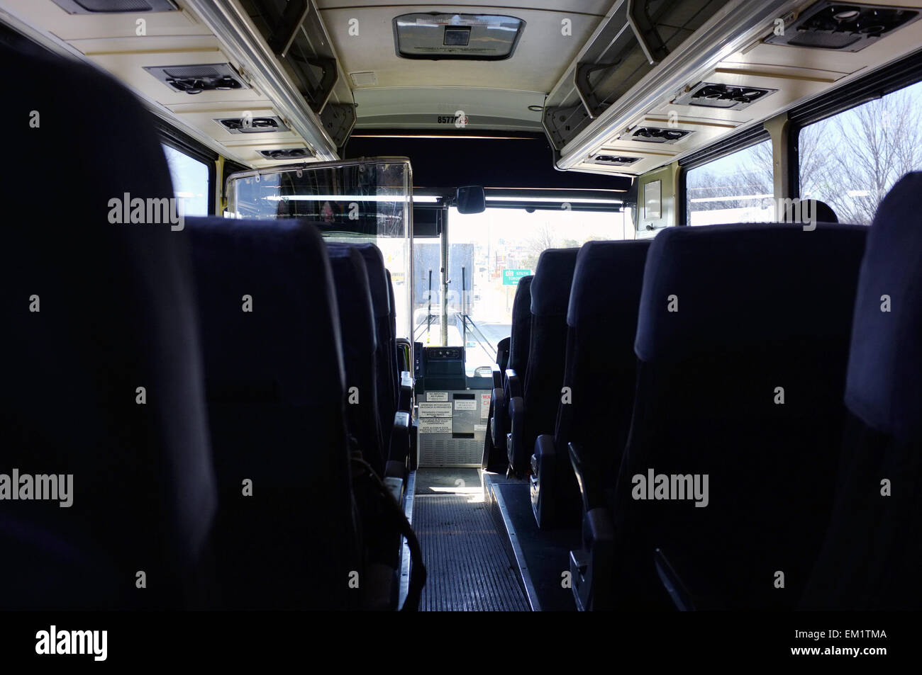 The view inside a Greyhound coach looking down a row of seats towards the driver. Stock Photo