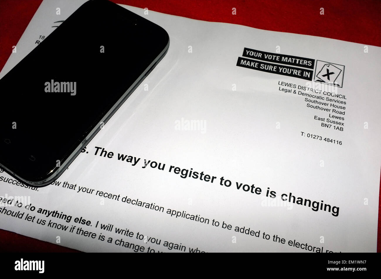 A smartphone laying on top of a voter registration form prior to the 2015 UK General Election. Stock Photo