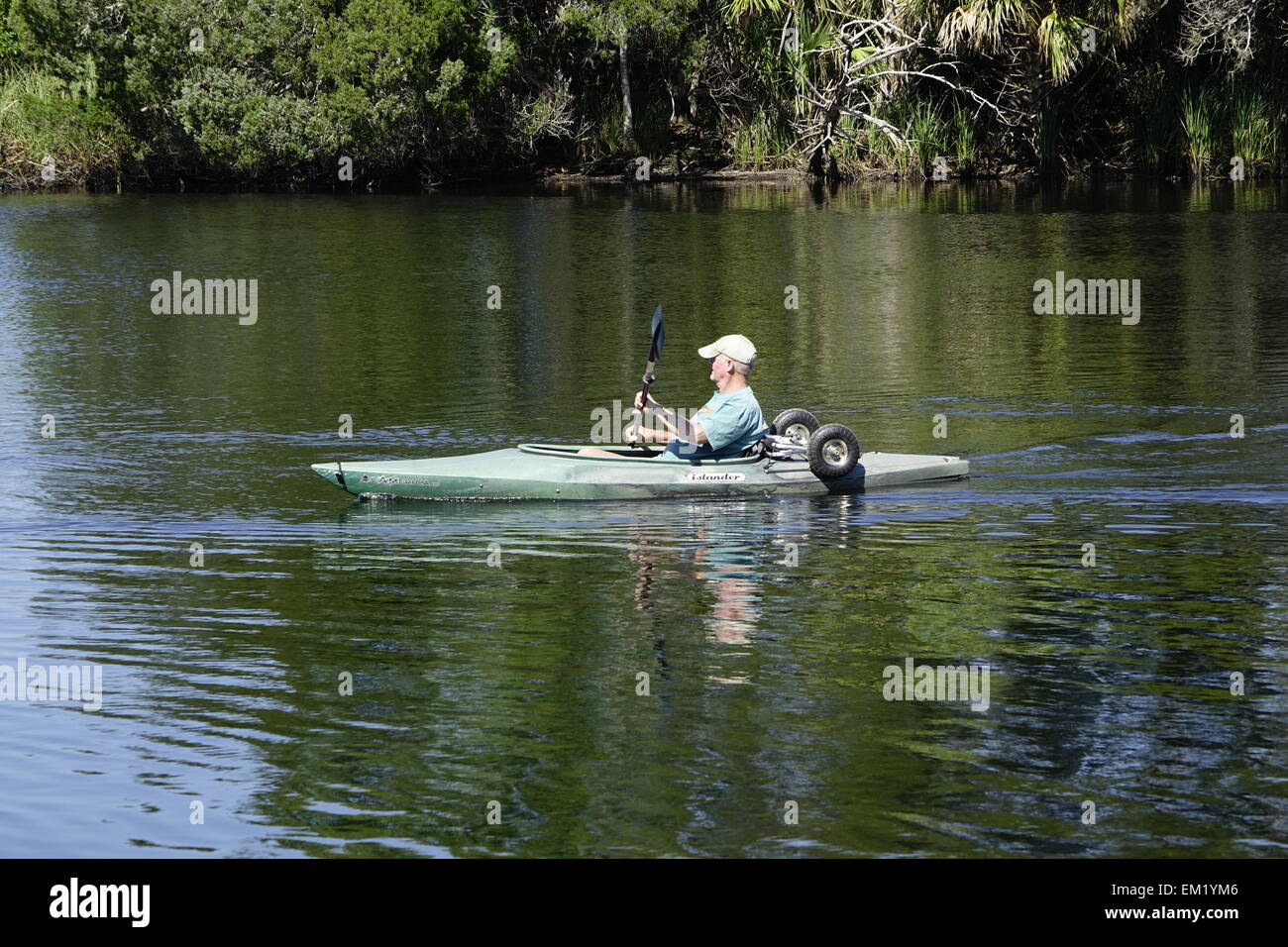 Man paddling Florida river with kayak carrier on board Stock Photo