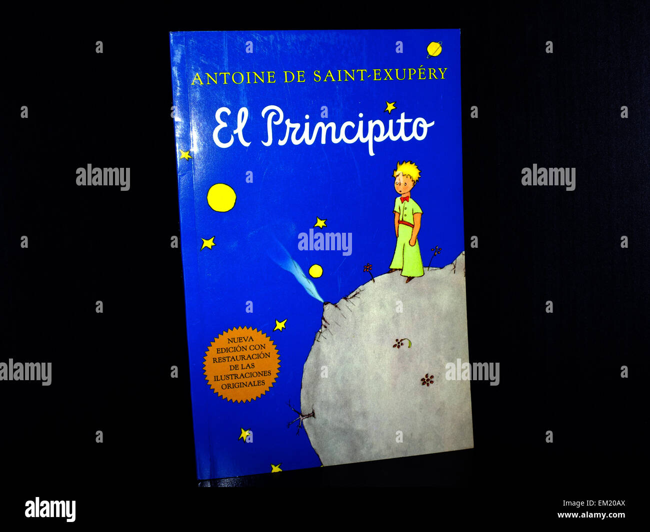 The front cover of a Spanish translation of The Little Prince book photographed against a black background. Stock Photo