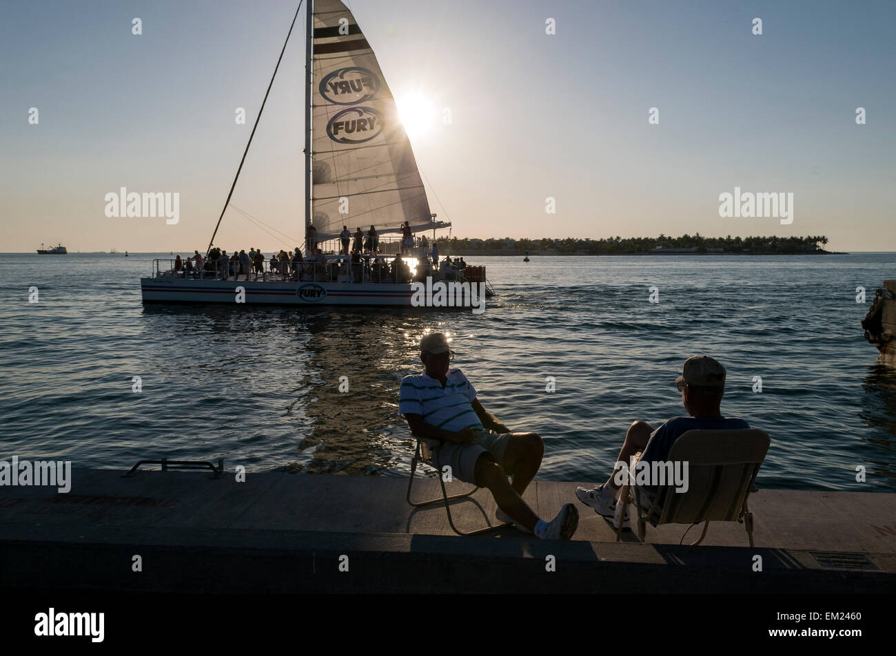 Sailboat with sightseers off Mallory Square during daily sunset celebration, Key West, Florida. Stock Photo