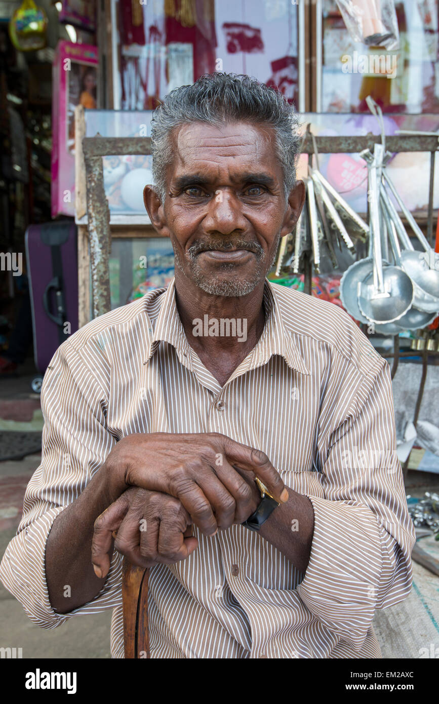 A man sitting outside a hardware shop in Munnar, Kerala India Stock Photo