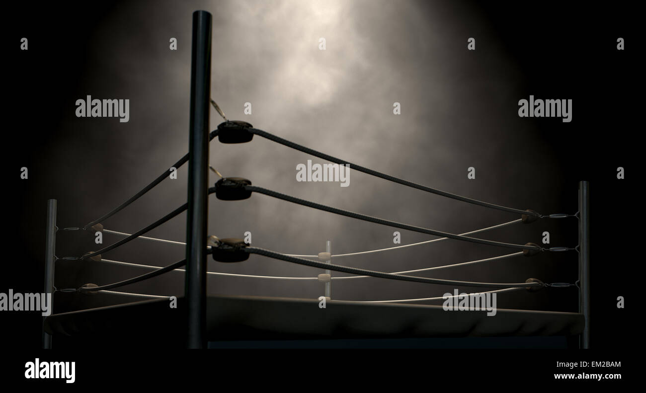 An old vintage boxing ring surrounded by ropes spotlit in the middle on an isolated dark background Stock Photo