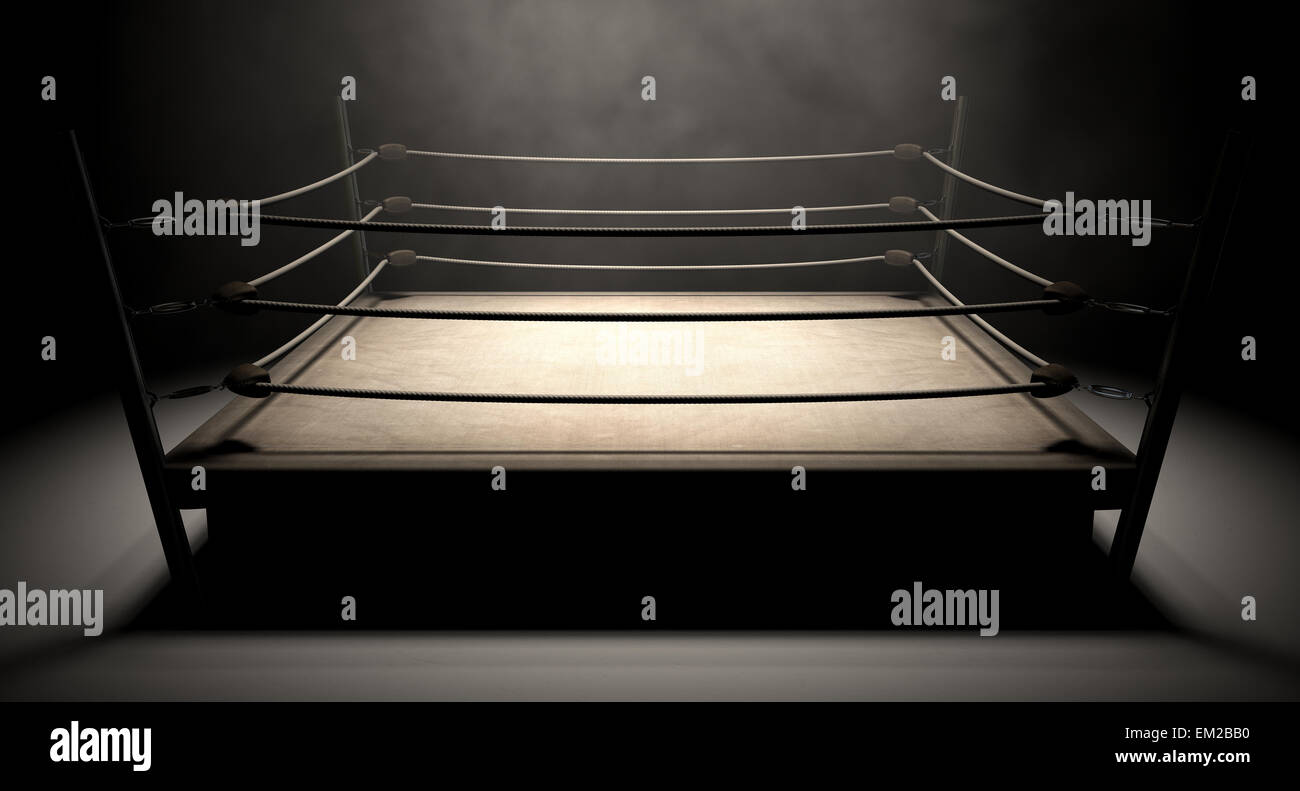 An old vintage boxing ring surrounded by ropes spotlit in the middle on an isolated dark background Stock Photo