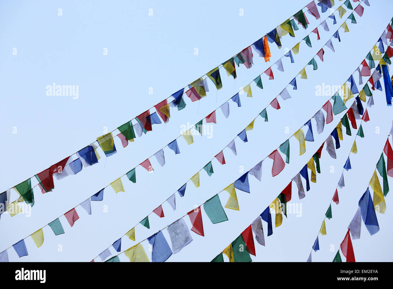 Buddhist tibetan prayer flags waving in the wind against blue sky ...