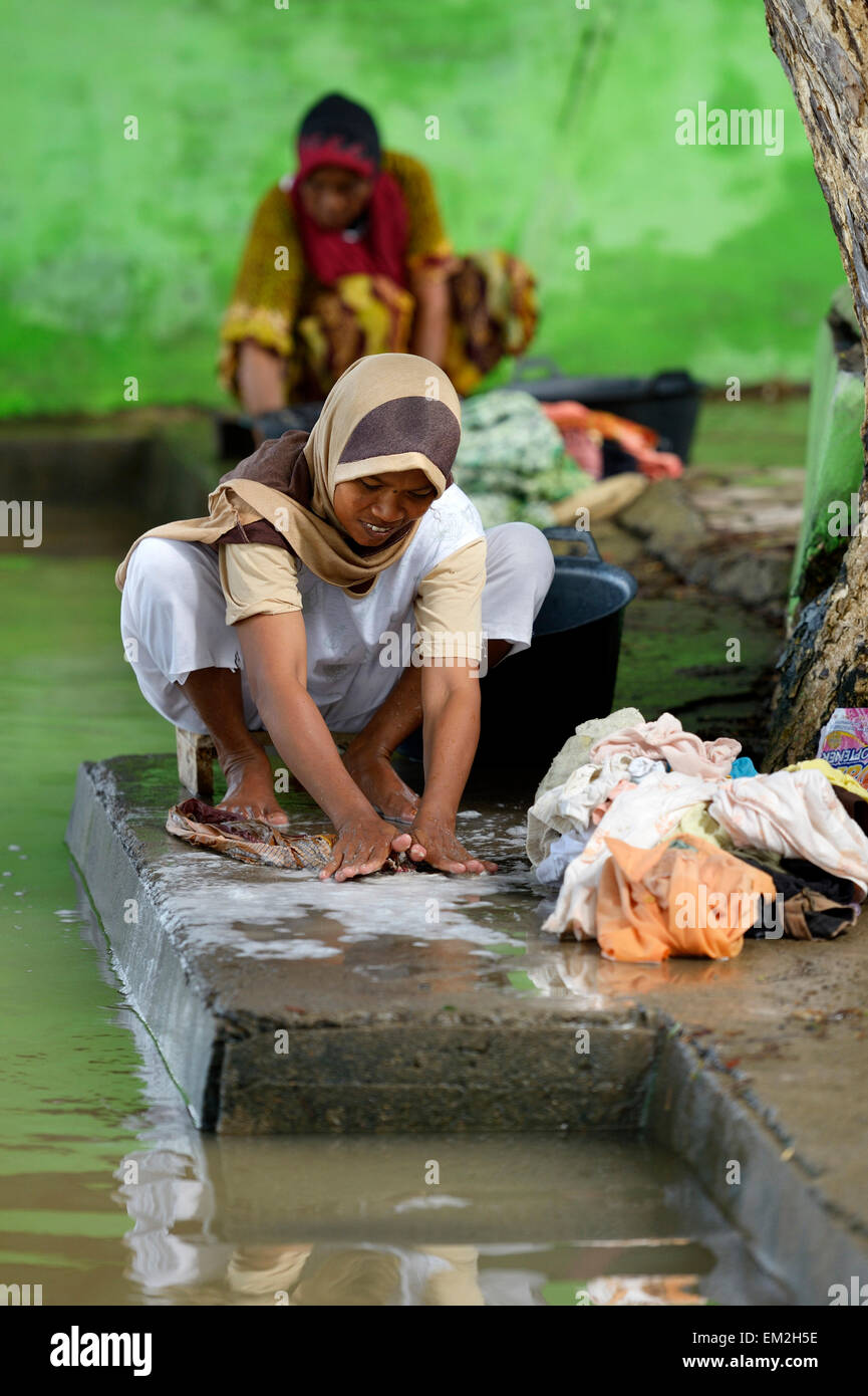 Woman washing laundry by the river, Nusa Gampong village, Aceh, Indonesia Stock Photo