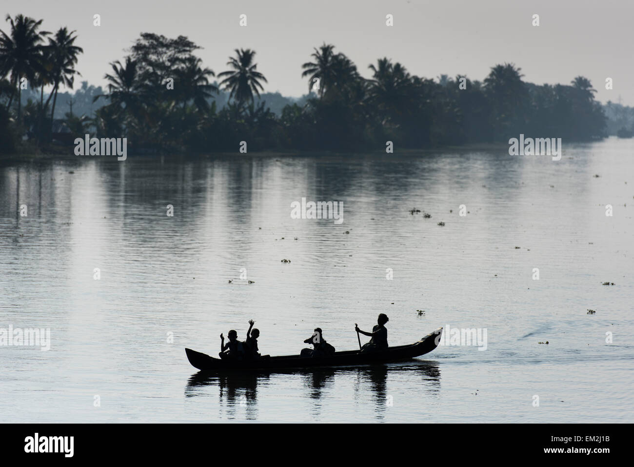 Woman taking children to school in a small boat, Backwaters canal system, Kerala, South India, India Stock Photo