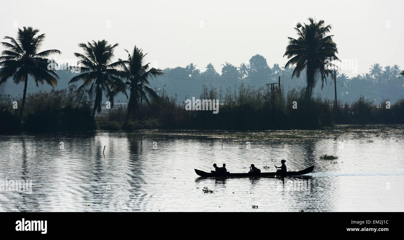 Woman taking children to school in a small boat, Backwaters canal system, Kerala, South India, India Stock Photo