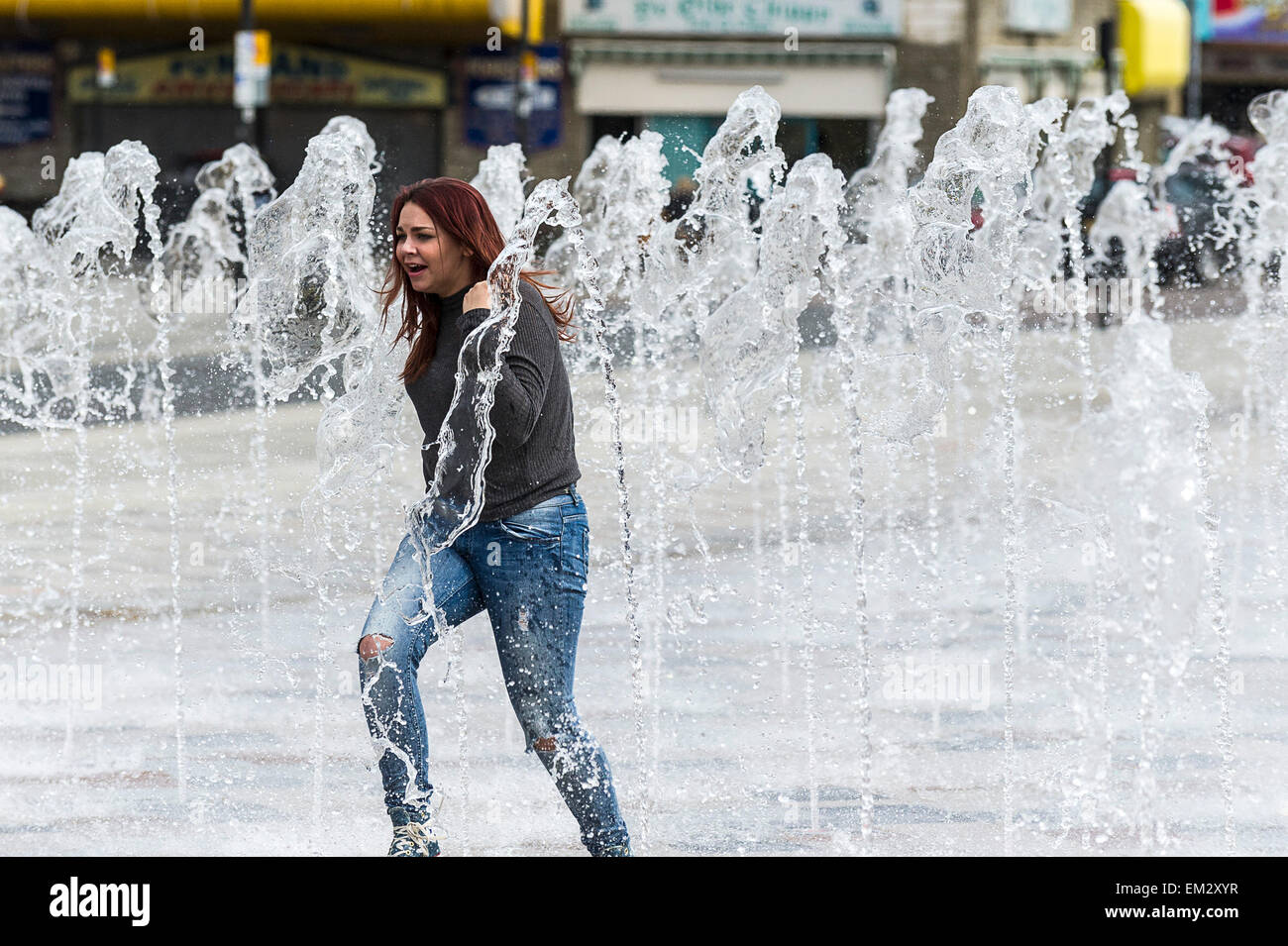 A girl running through the fountain on Southend seafront in Essex. Stock Photo