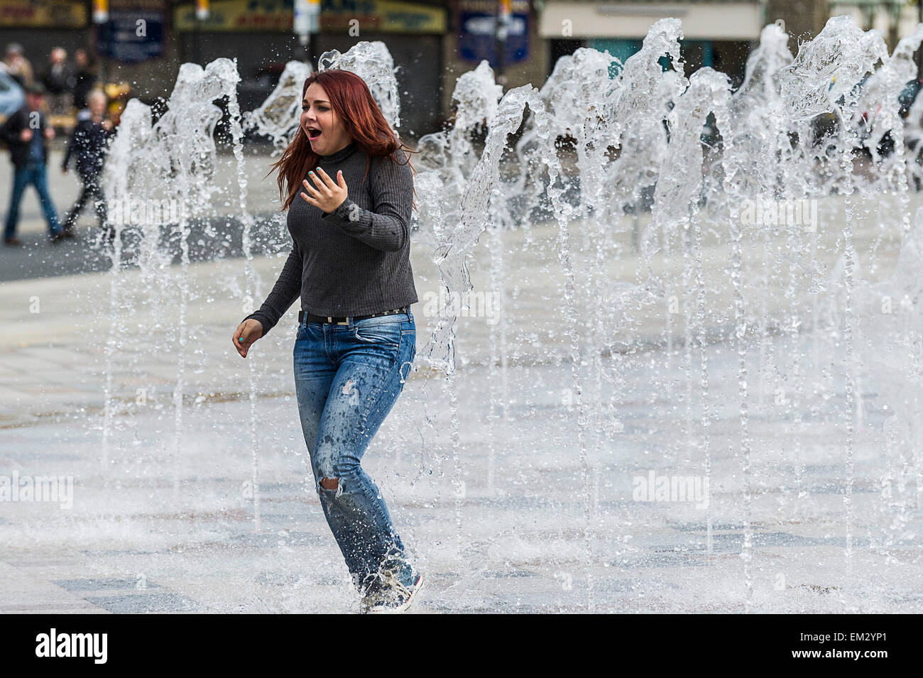 A girl running through the fountain on Southend seafront in Essex. Stock Photo