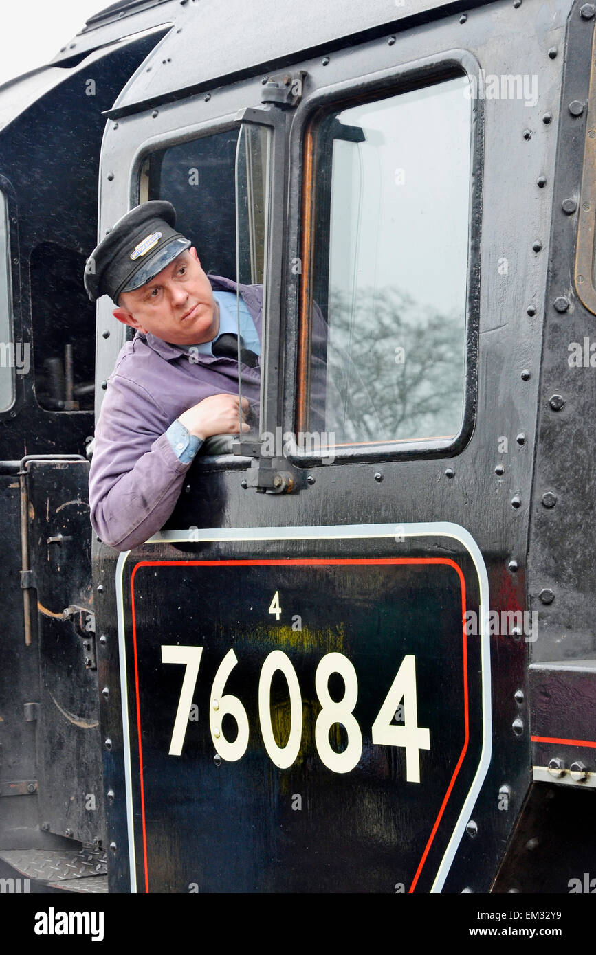 The fireman of steam loco 76084 watches carefully as the engine buffers up to carriages at Holt Station, North Norfolk Railway. Stock Photo