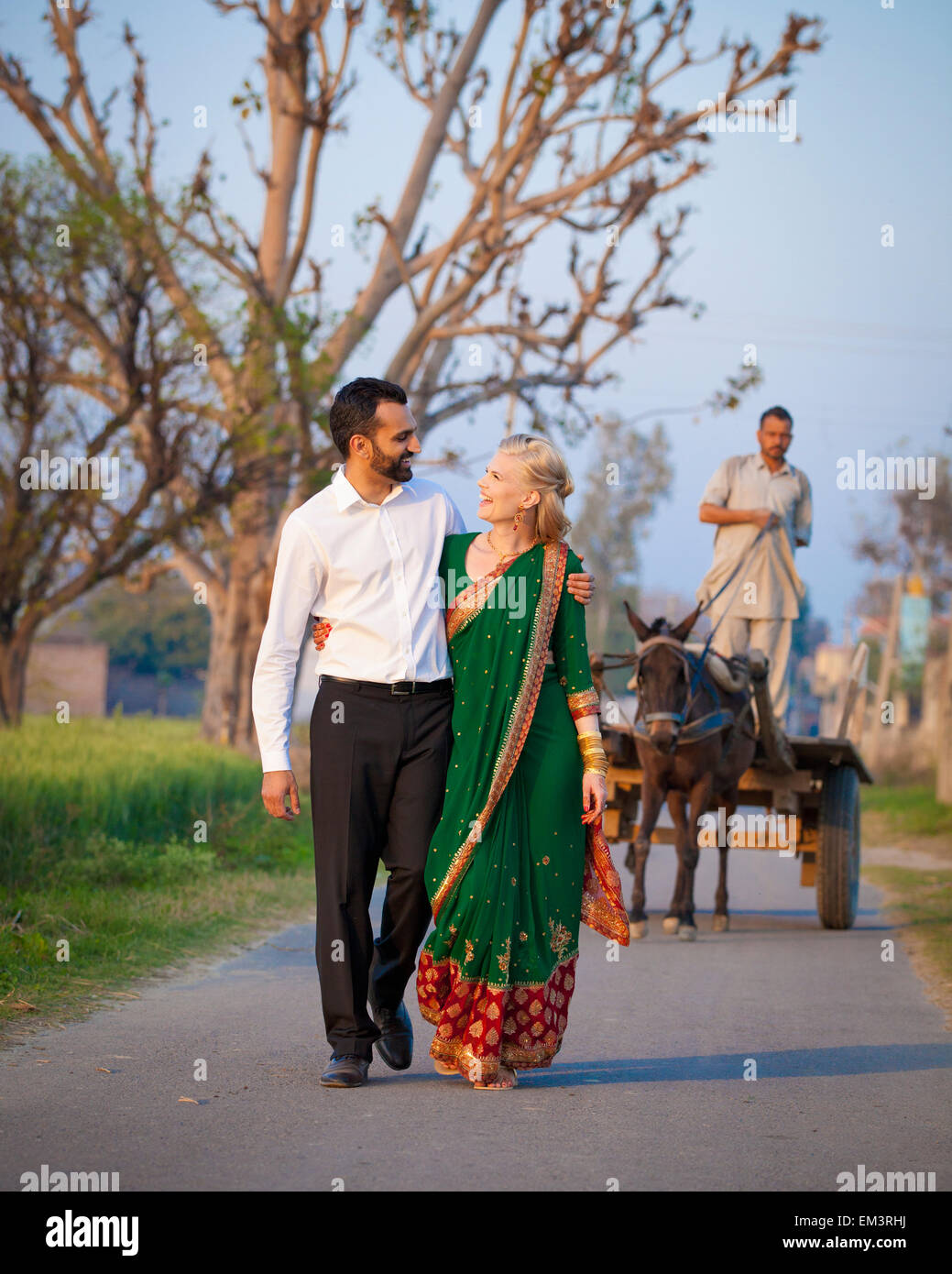 A Mixed Race Couple Walking In An Embrace Down A Path; Ludhiana, Punjab, India Stock Photo