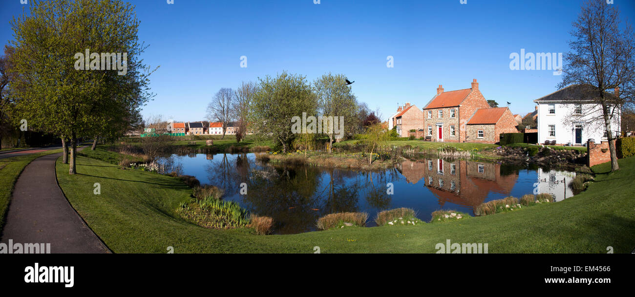 Houses Reflected In A Tranquil Pond; East Witton Yorkshire England