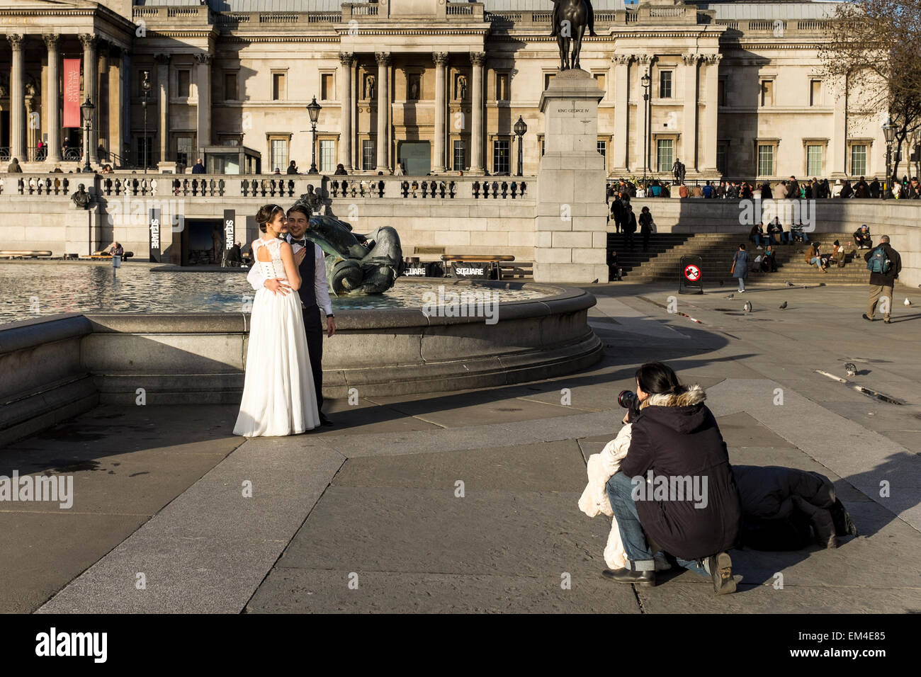 Newly married yYoung couple having wedding photos taken at Trafalgar Square in London, UK Stock Photo