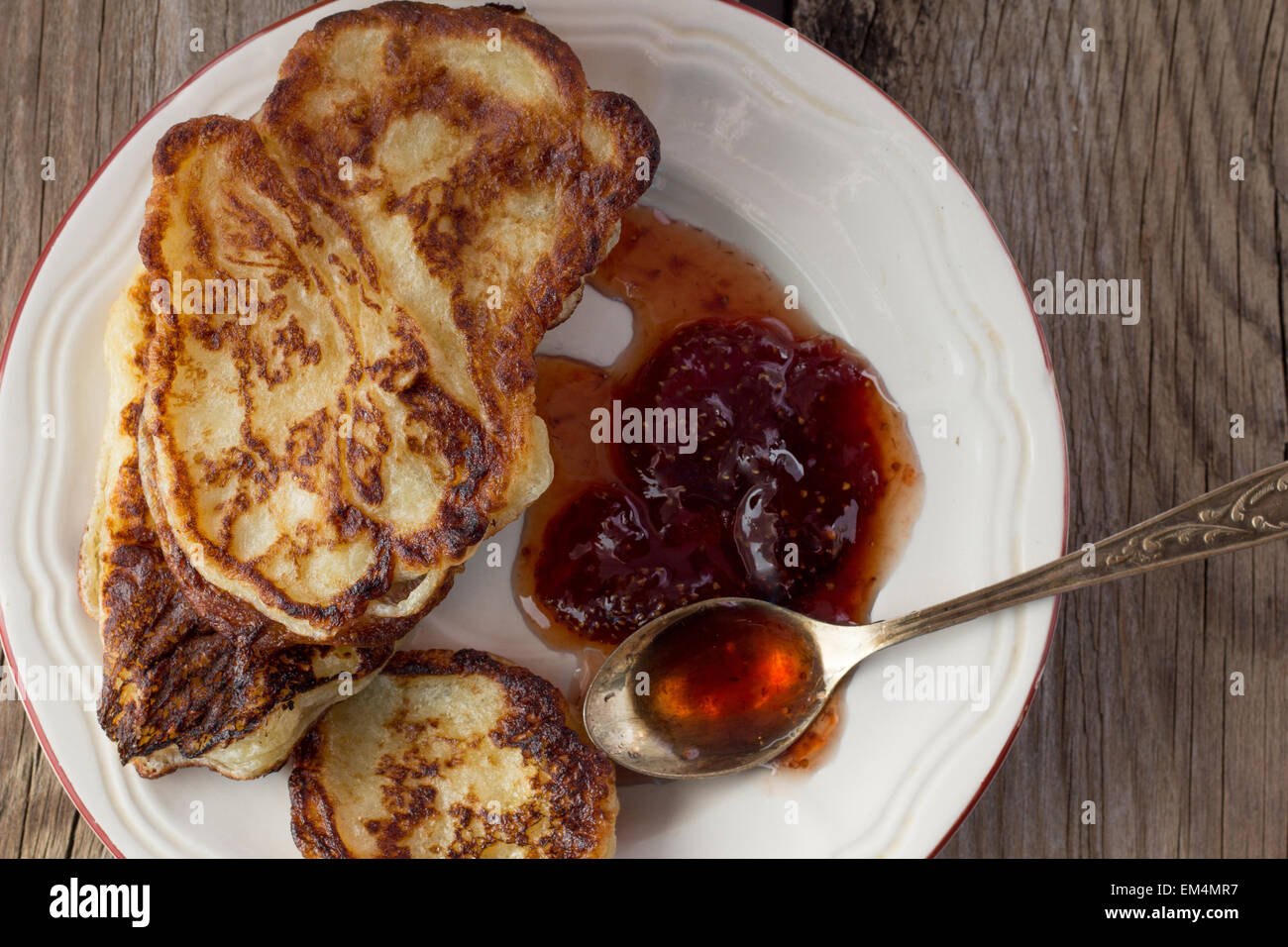Shot of plate with pancakes and jam metal spoon top view Stock Photo