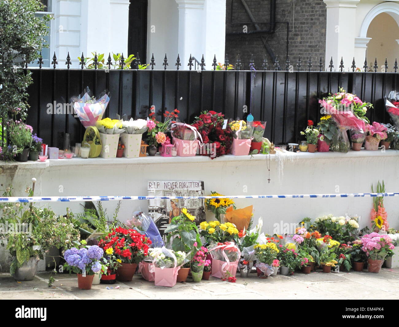 Fans leave flowers for Amy Winehouse after her death, outside her home in Camden London in July 2011 Stock Photo