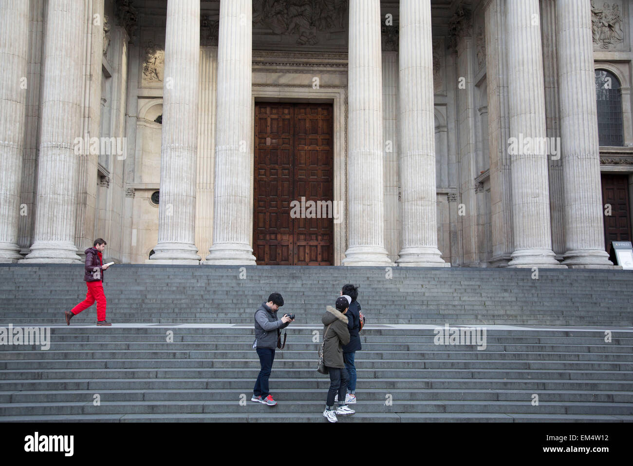 Tourists at St Paul's Cathedral take their various photo opportunities. London, UK. St Paul's is a Church of England cathedral. St Paul's sits at the highest point in the City of London. The present church dating from the late 17th century was built to an English Baroque design of Sir Christopher Wren, as part of a major rebuilding program which took place in the city. Stock Photo