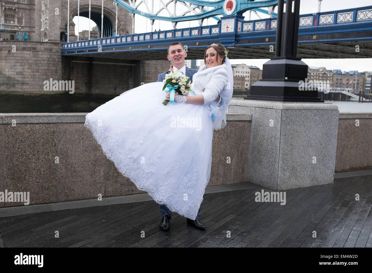Russian bride and groom having their wedding photos taken at Tower Bridge, London, UK. It is a common site to see Russian and other nationalities having pre-wedding photographs taken at famous sites around the capital. Stock Photo