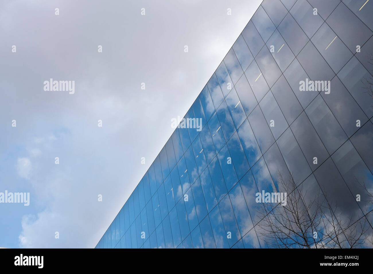 Glass building reflecting the clouds in a blue sky. Modern architecture ...