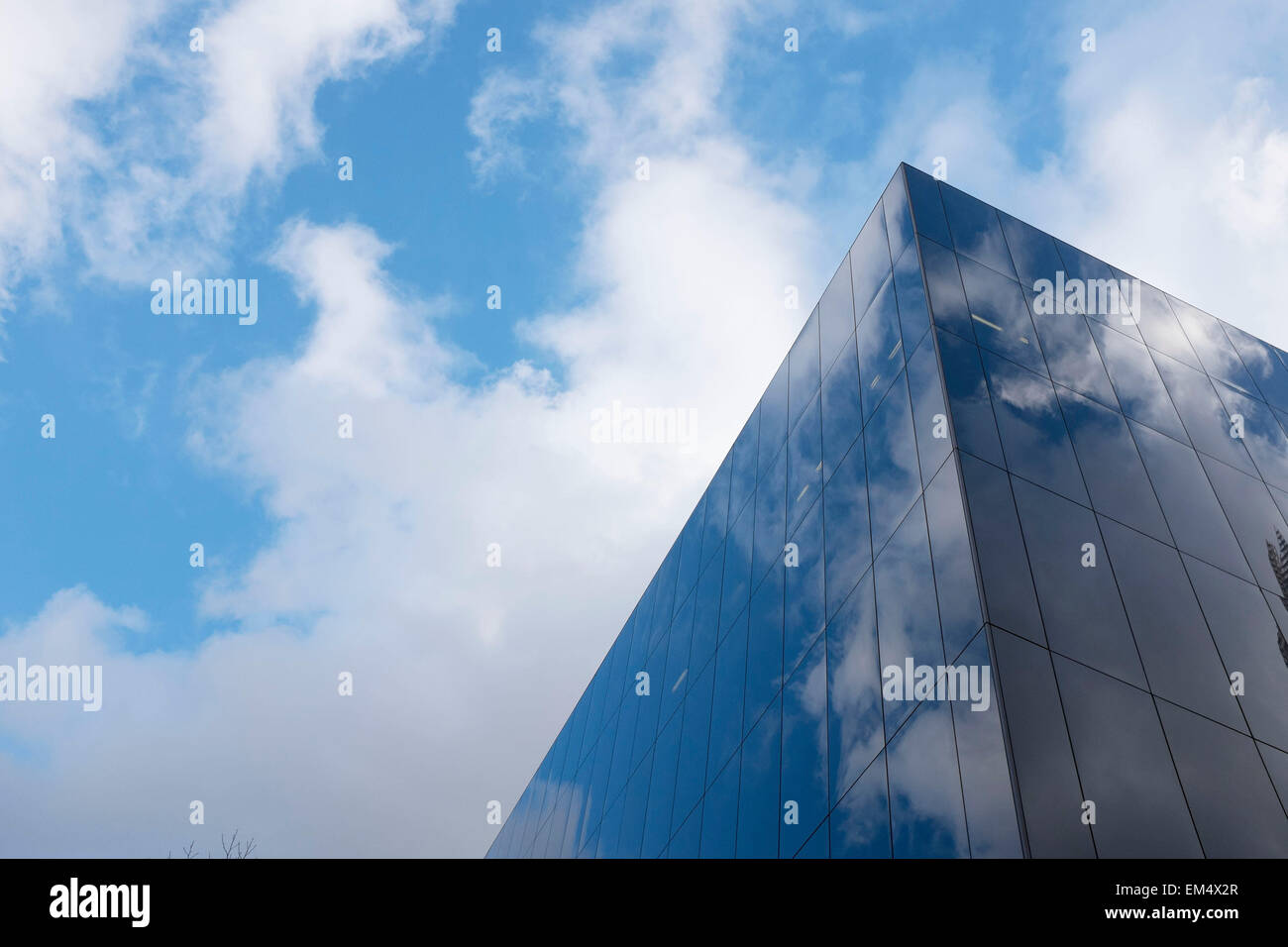 Glass building reflecting the clouds in a blue sky. Modern architecture ...
