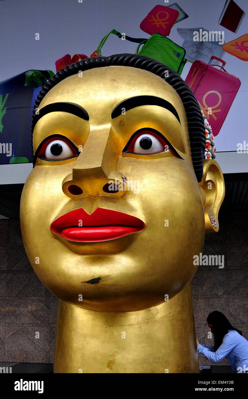 Bangkok, Thailand:  An enormous gilded contemporary bust of Buddha stands in front of the Central World shopping center Stock Photo