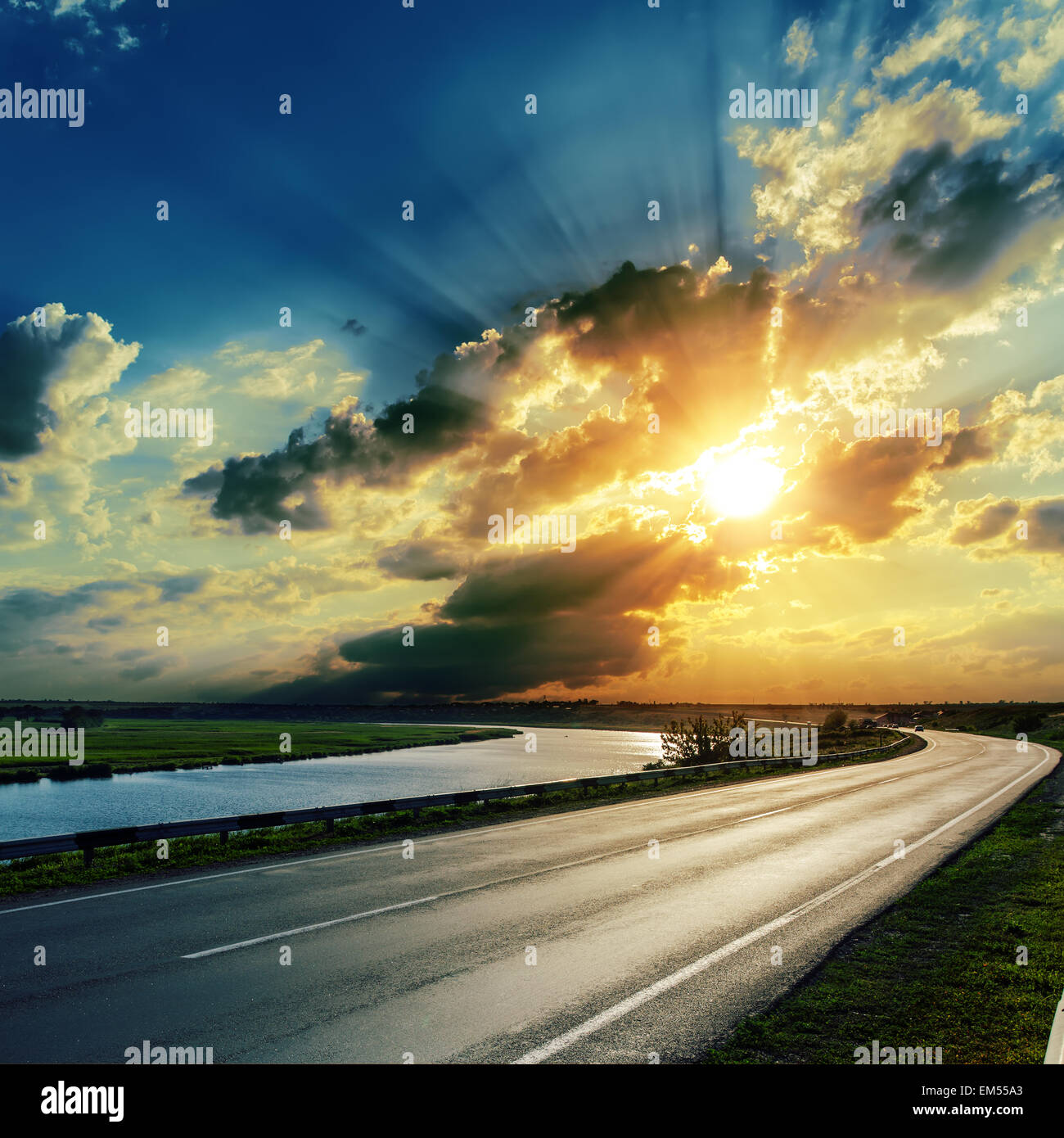 sunset over asphalt road and river Stock Photo - Alamy