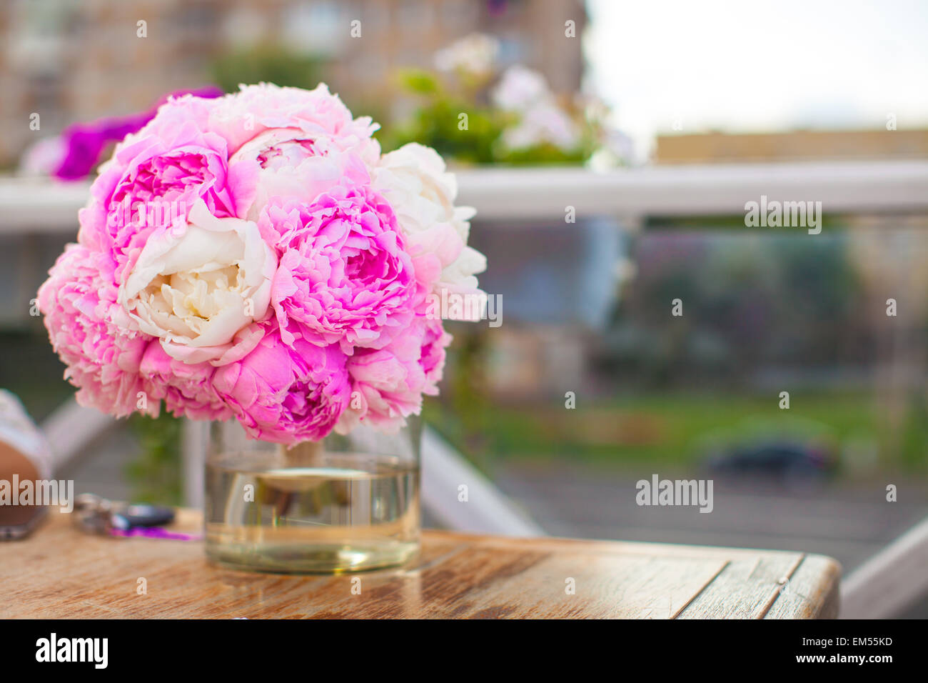 Charming bouquet of peonies in vase on table at restaurant Stock Photo