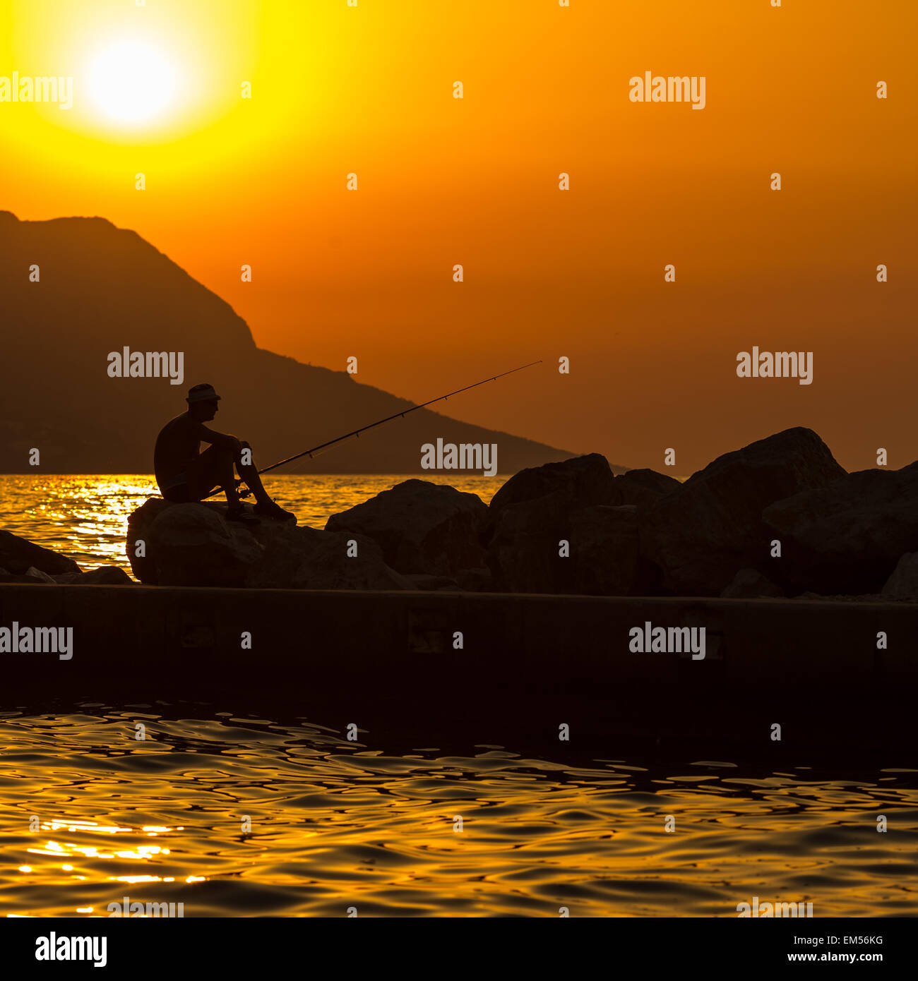 Fisherman's silhouette on the beach at colorful sunset Stock Photo - Alamy