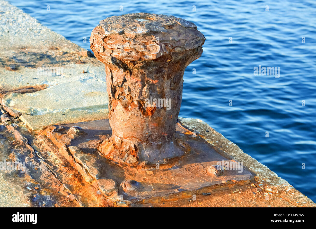 Closeup of an old anchor with rust on the pier at sunset Stock Photo