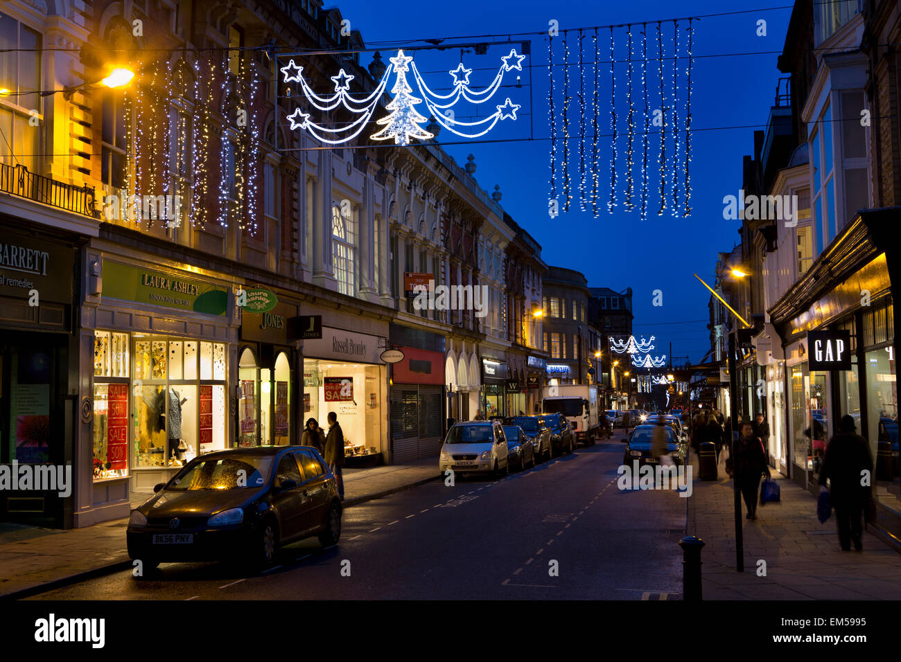 UK, England, Yorkshire, Harrogate at Christmas, James Street, lights above shops at dusk Stock