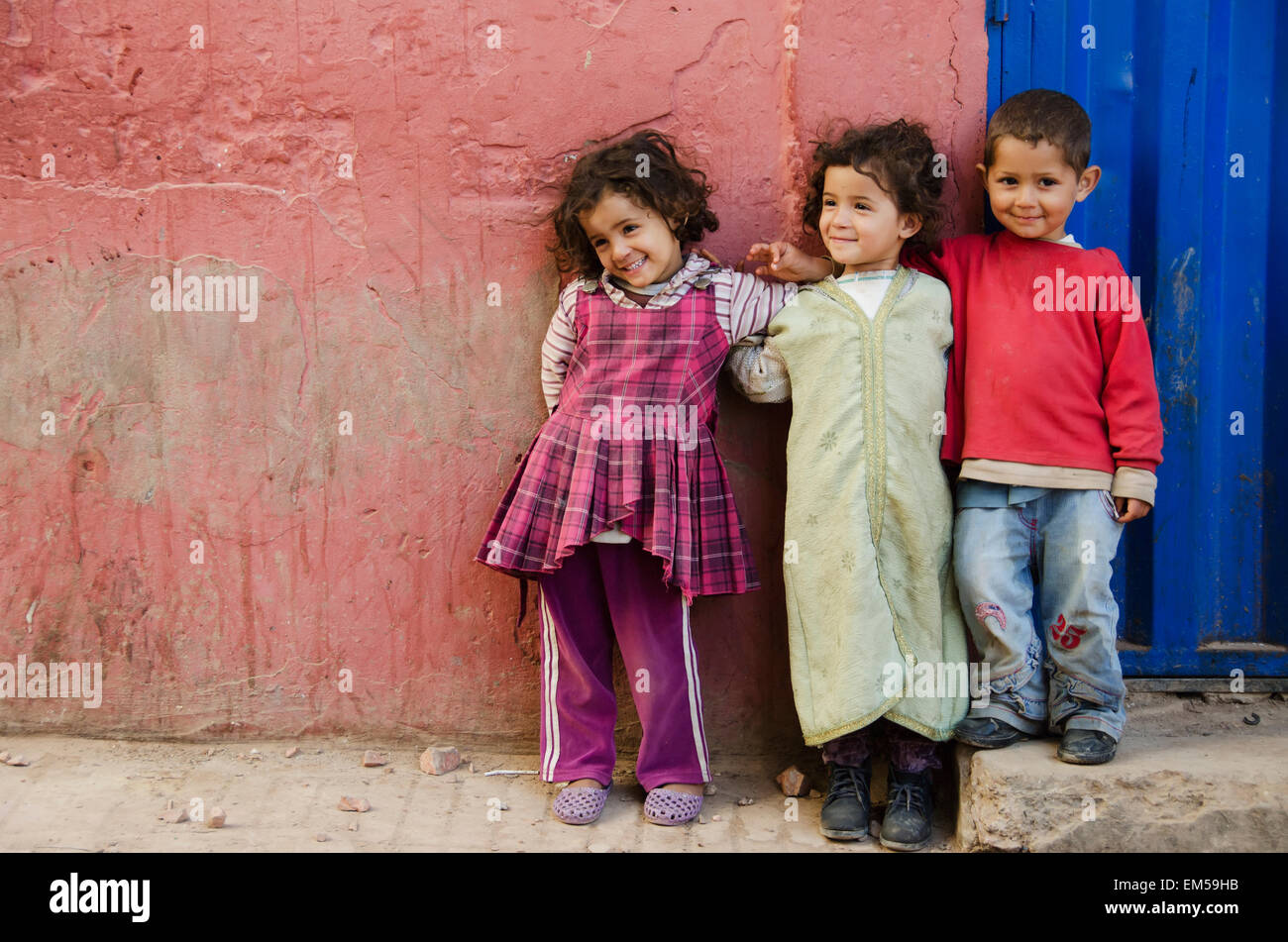 Three young children standing against wall; Old Medina, Casablanca, Morocco Stock Photo