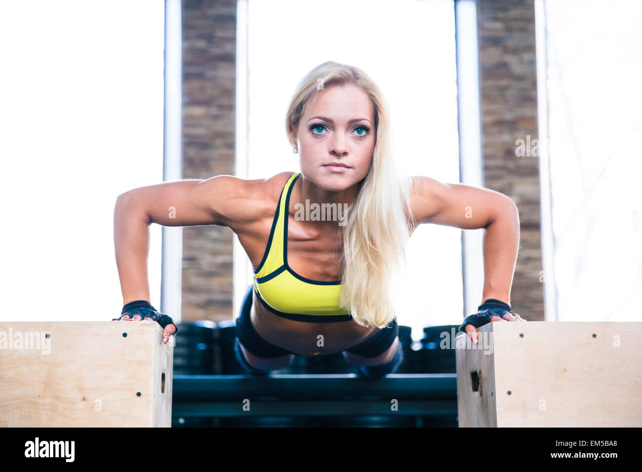 Young beautiful sports woman doing push ups on fit box at gym Stock ...