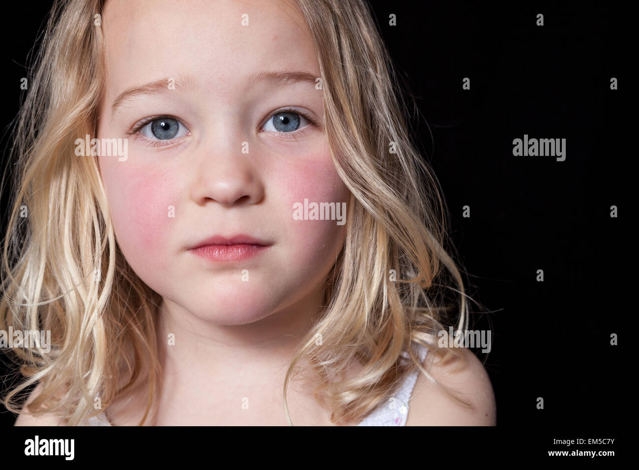 Portrait of a contemplative young girl on black background. Stock Photo