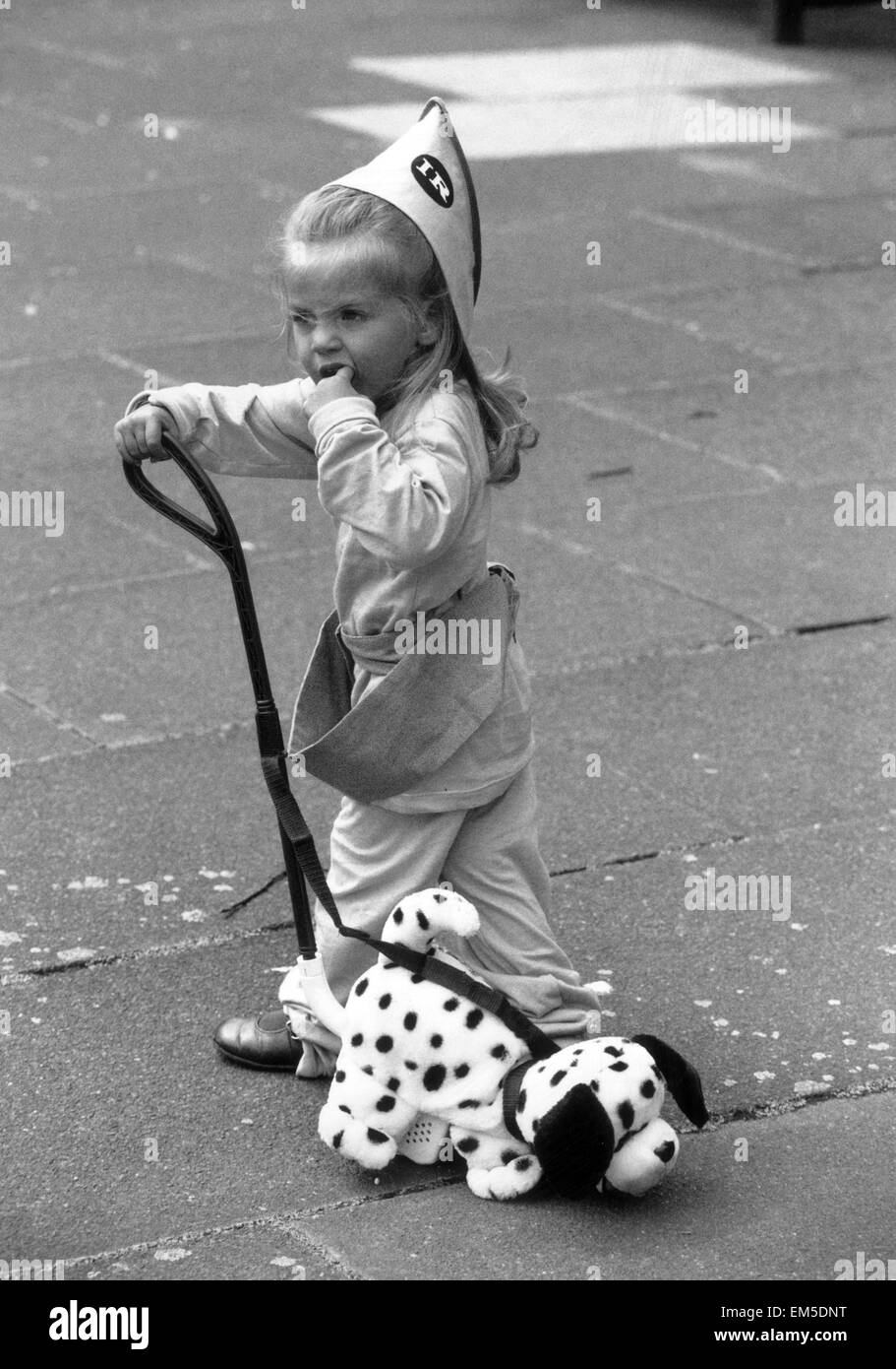 2 year old Thea Behbahani tries out a new plastic trike and nodding dog. 24th June 1992 Stock Photo