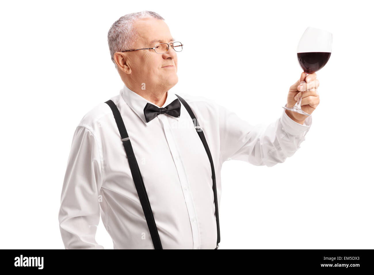 Classy senior gentleman looking at a glass full of red wine isolated on white background Stock Photo