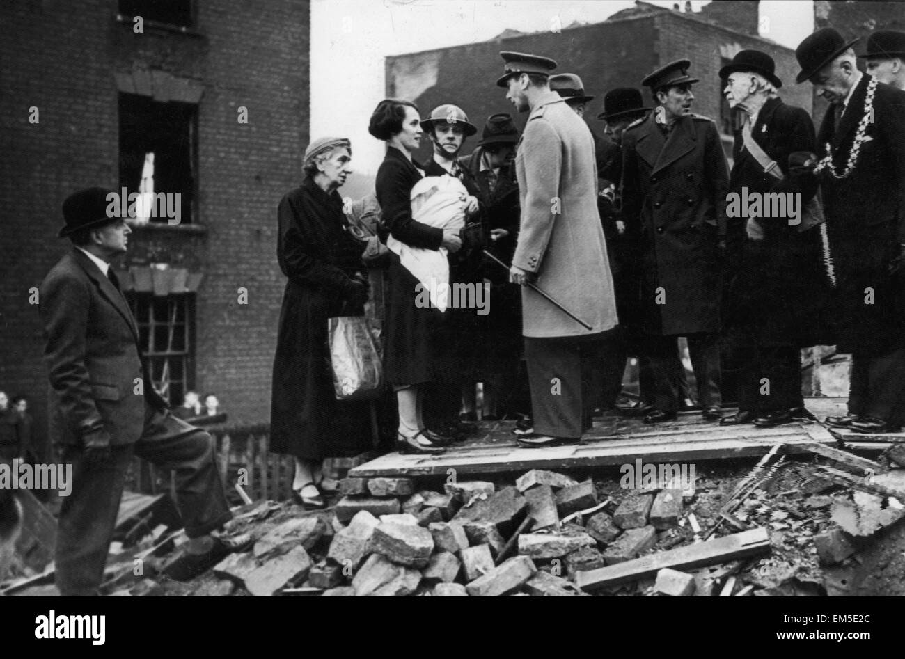 King George VI meets residents of a bombed street during his visit to the city of Bristol following an air raid. December 1940. Stock Photo