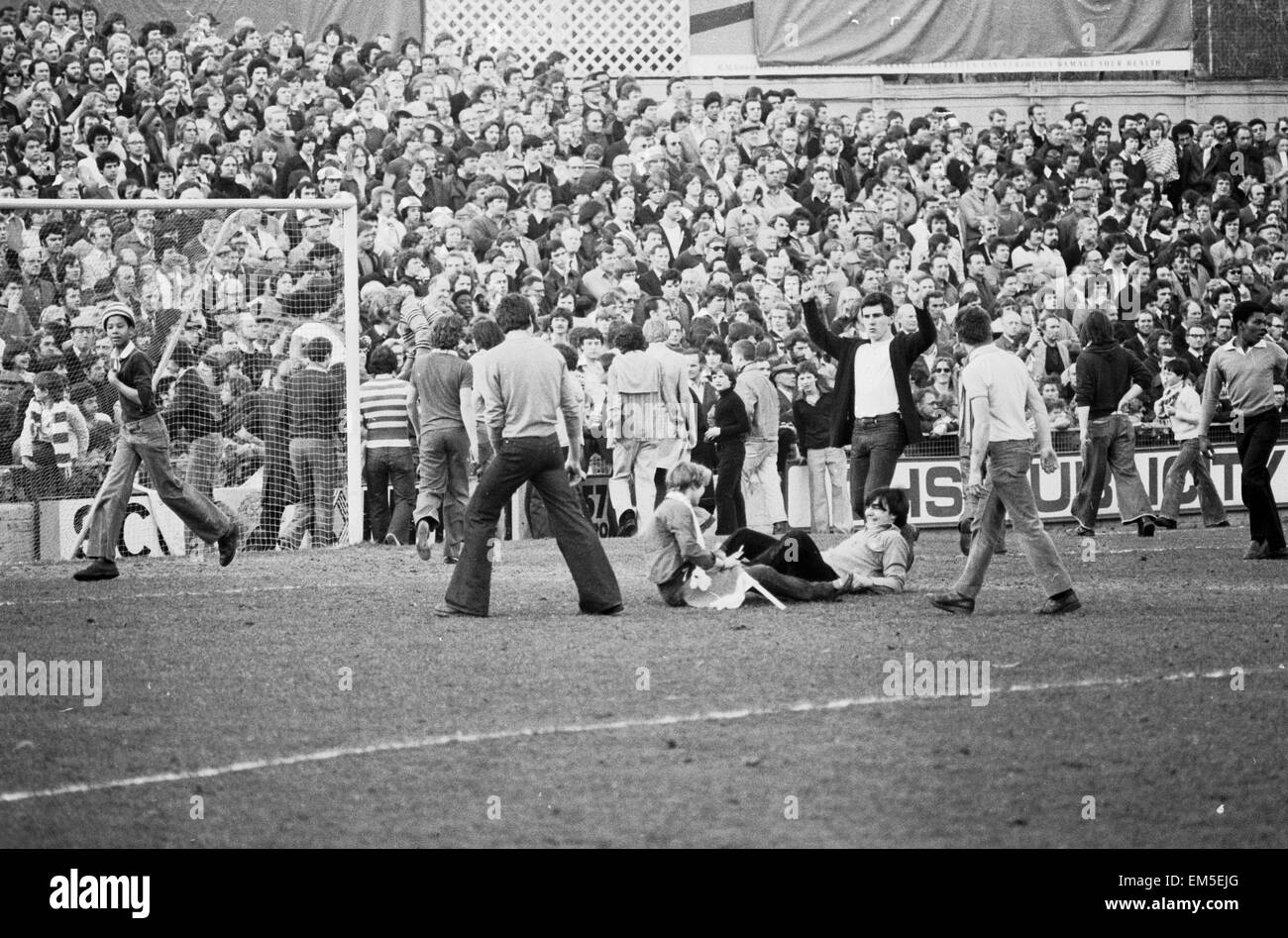 March 1978, a full-scale riot breaks out at The Den during an FA Cup quarter-final between Millwall and Ipswich. Fighting began on the terraces, then spilled out on to the pitch and into the narrow streets around the ground 11th March 1978 Our Picture show Millwall fans running on to the pitch Stock Photo