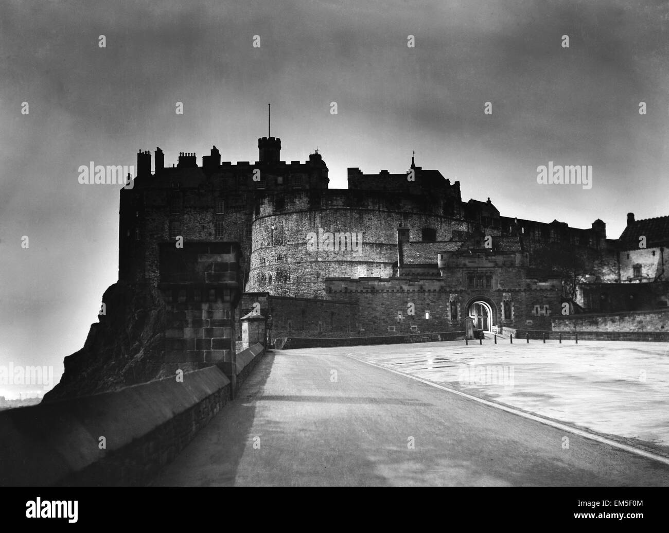 The light from Princes Street forms a halo around Edinburgh Castle as dusk falls on the Scottish Capital, circa 1935. Stock Photo
