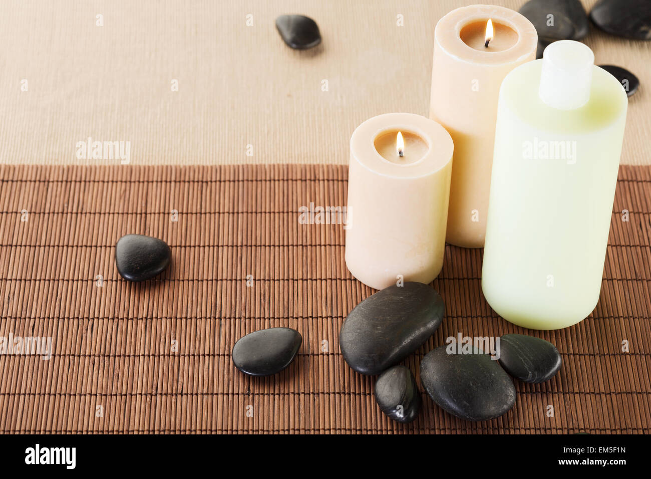 shampoo bottle, massage stones and candles Stock Photo