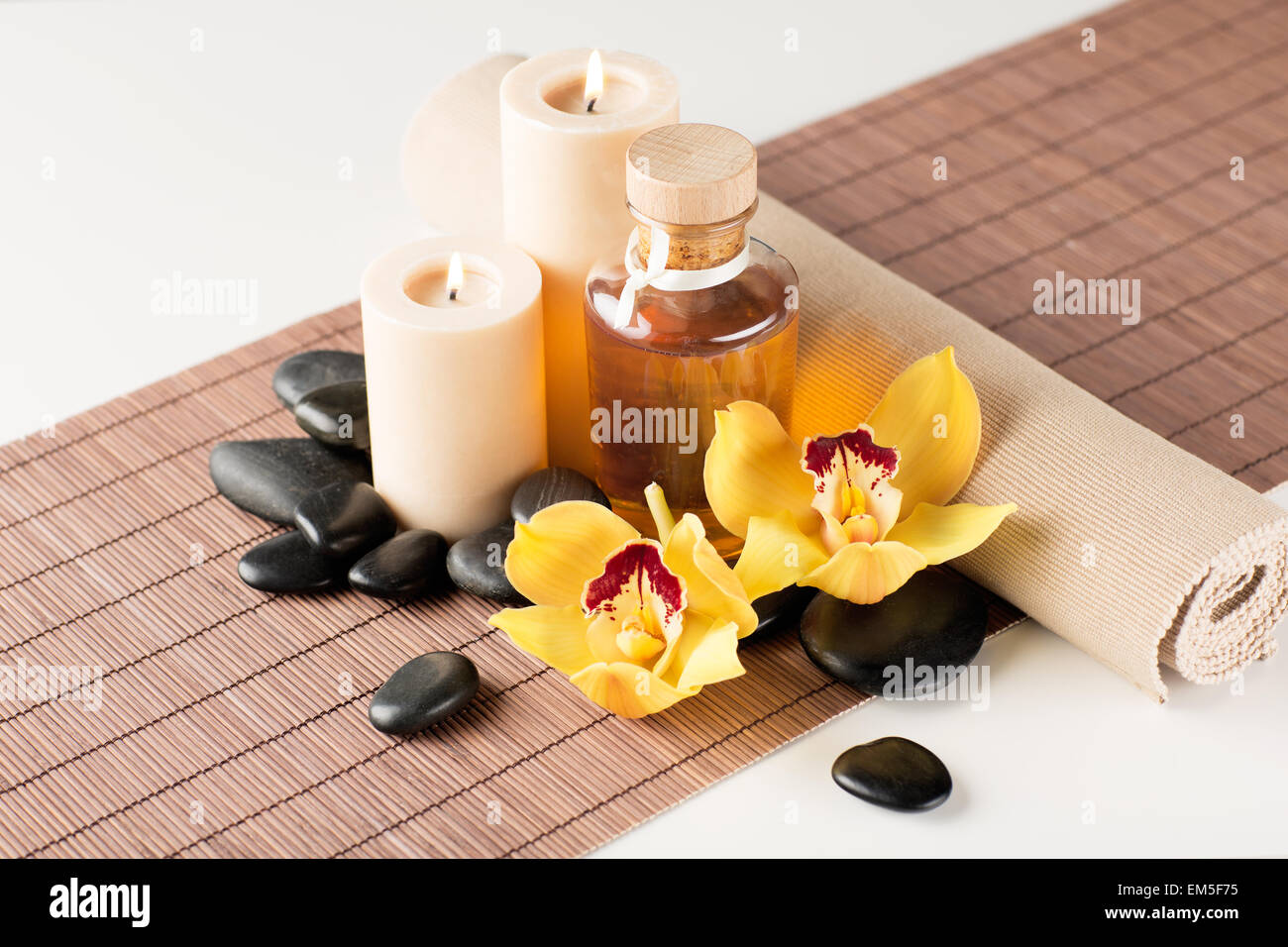 essential oil, massage stones and orchid flower Stock Photo