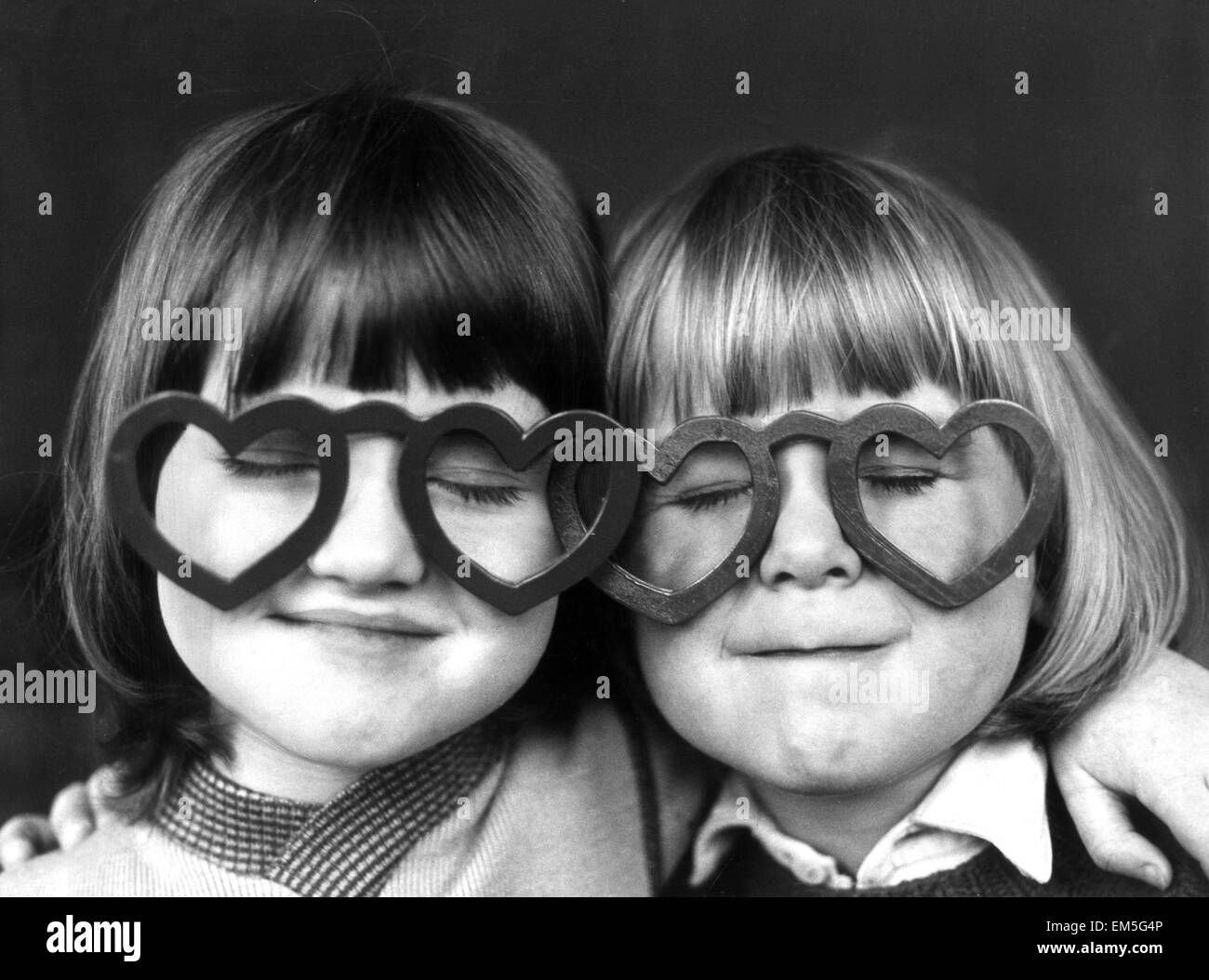 Four year old Sheldon Neal (right) and Terry Green, wearing love heart shaped glasses at the Rainbow Nursery in Brighton. 12th February 1976. Stock Photo