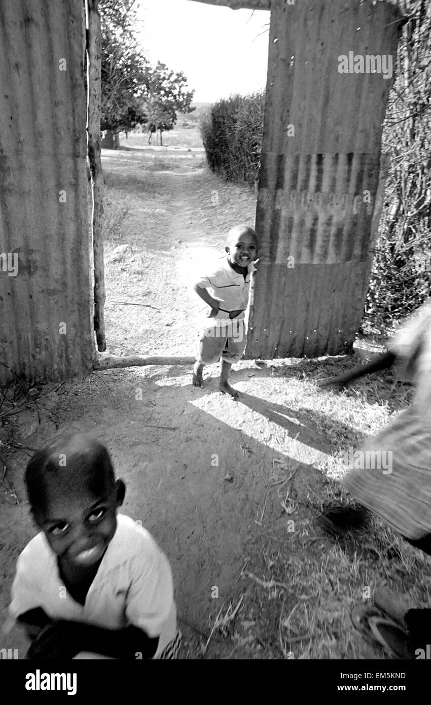 Children play in rural Kenya. Ikutha, Kitui, Kenya. Many children lack adequate food, such as proteins from red meat, milk or fish. Ikutha is a town from the Sub-Sahara Africa punished by whips of the AIDS, the lack of water and educative and sanitary resources. During years there is no development worked against zones more disadvantaged and the international aids have still not arrived at this zone. This rural locality has only around 500 inhabitants and is located in the heart of Kenya already worn away by a government who has corrupted it for more than 20 years. Stock Photo