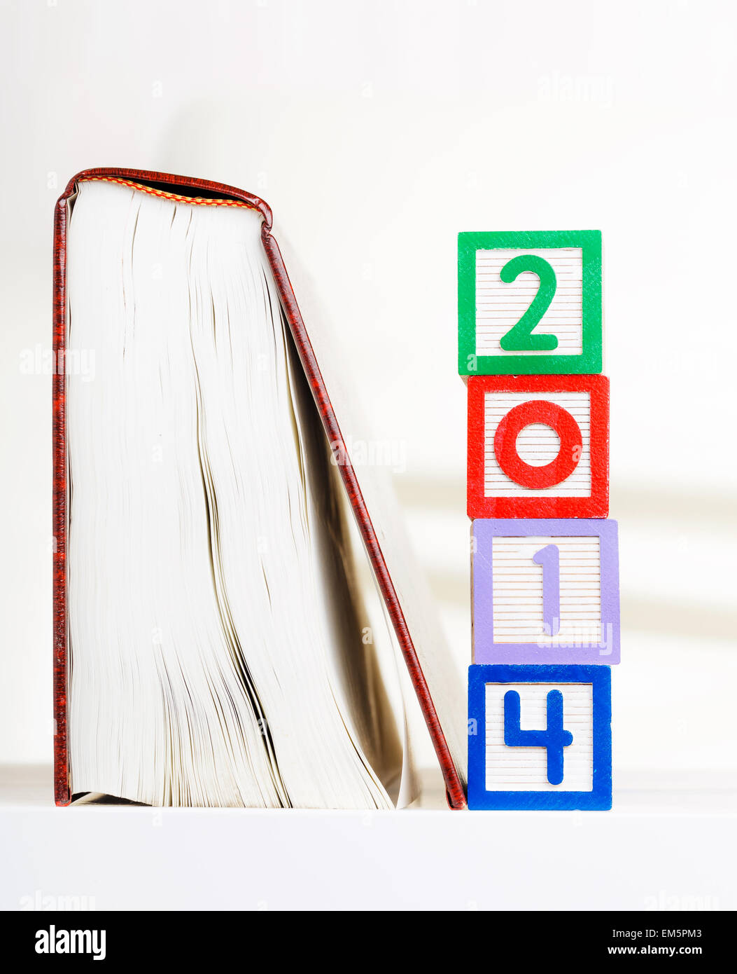 Alphabet block with 2014 besides book Stock Photo