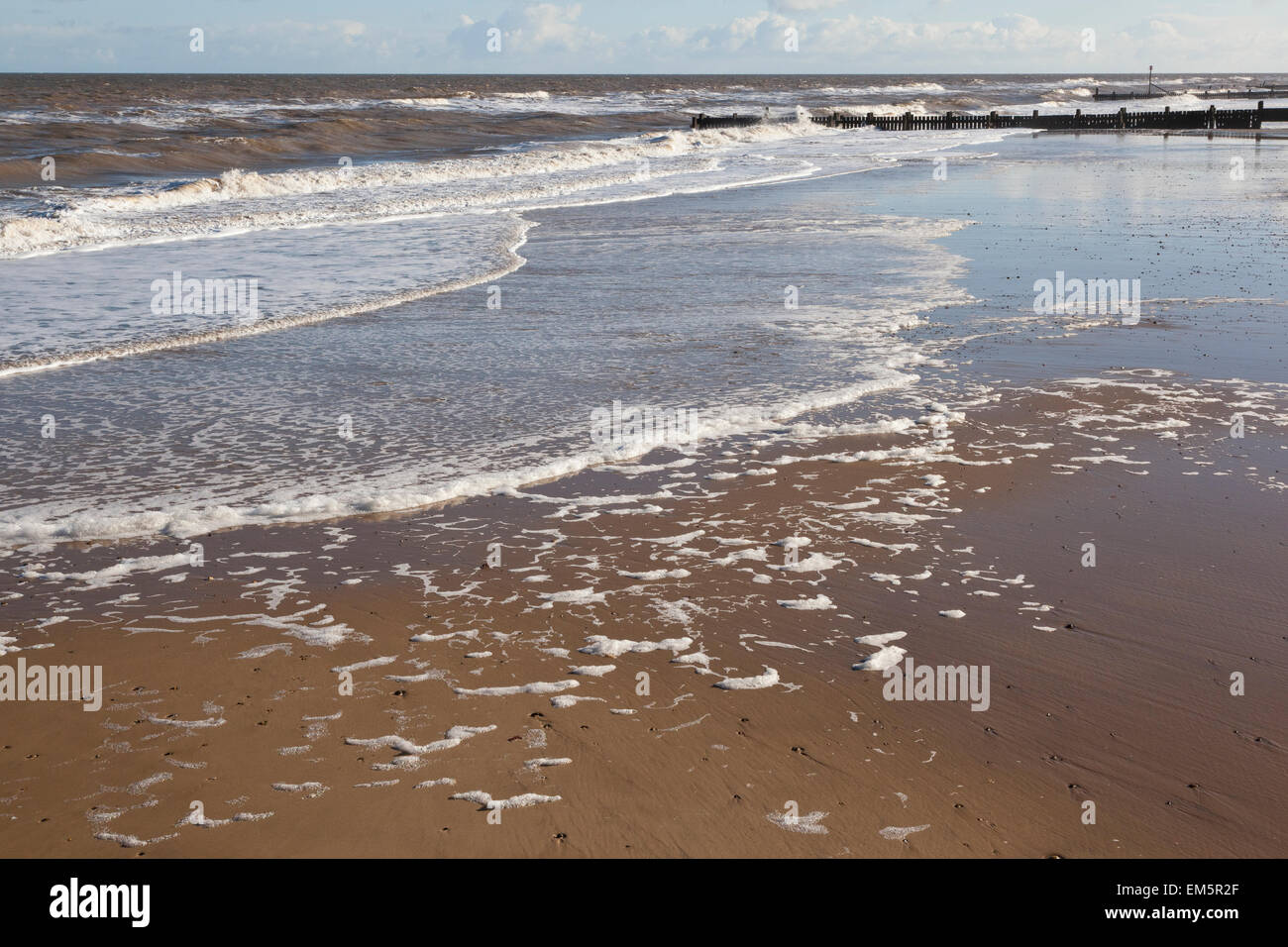 A blustery winter day at Walcott beach, Norfolk England UK. Foam blowing off the sea. Stock Photo