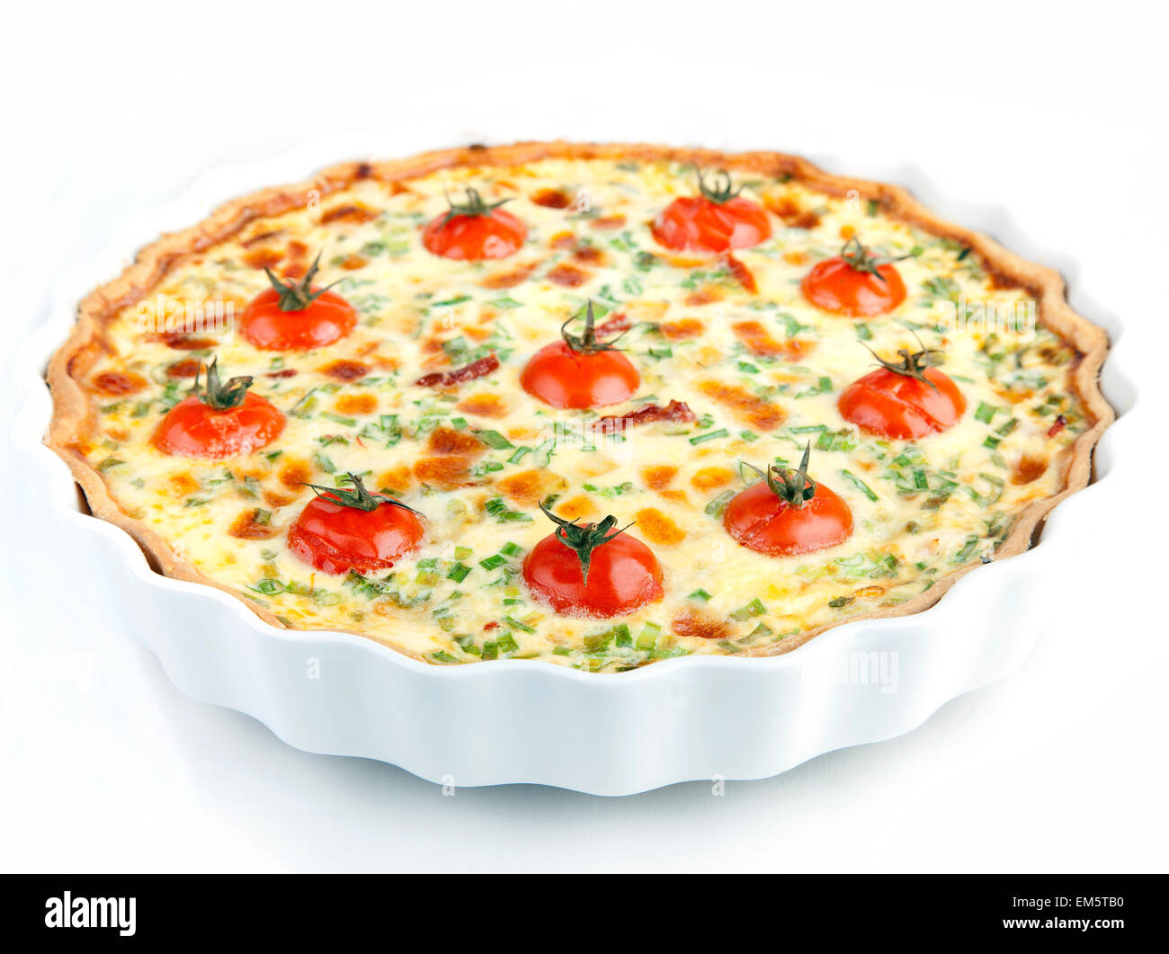 Quiche with cherry tomatoes and herbs on a white plate Stock Photo