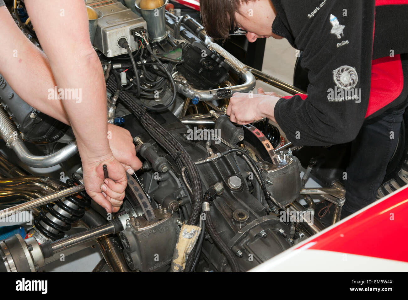 Mechanics work on  the  brakes of a classic Embassy Hill,  1973, F1 Shadow DN1 race car,  in the pits at Silverstone,  Part of the official media preview day, of the 2015 Silver Anniversary Silverstone Classic Stock Photo