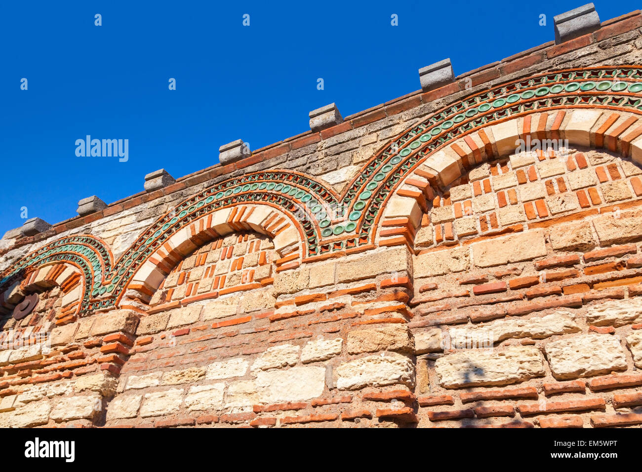 Old stone wall with ancient pattern and clear blue sky, Church in Nessebar town, Bulgaria Stock Photo