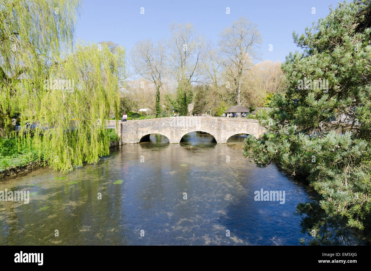 Old stone bridge over the River Coln in the Cotswold village of Bibury