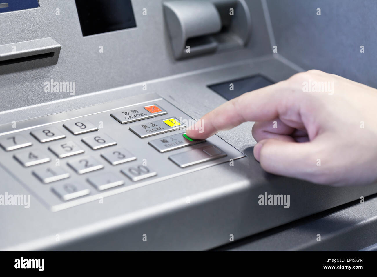 Human hand touching ATM machine Stock Photo