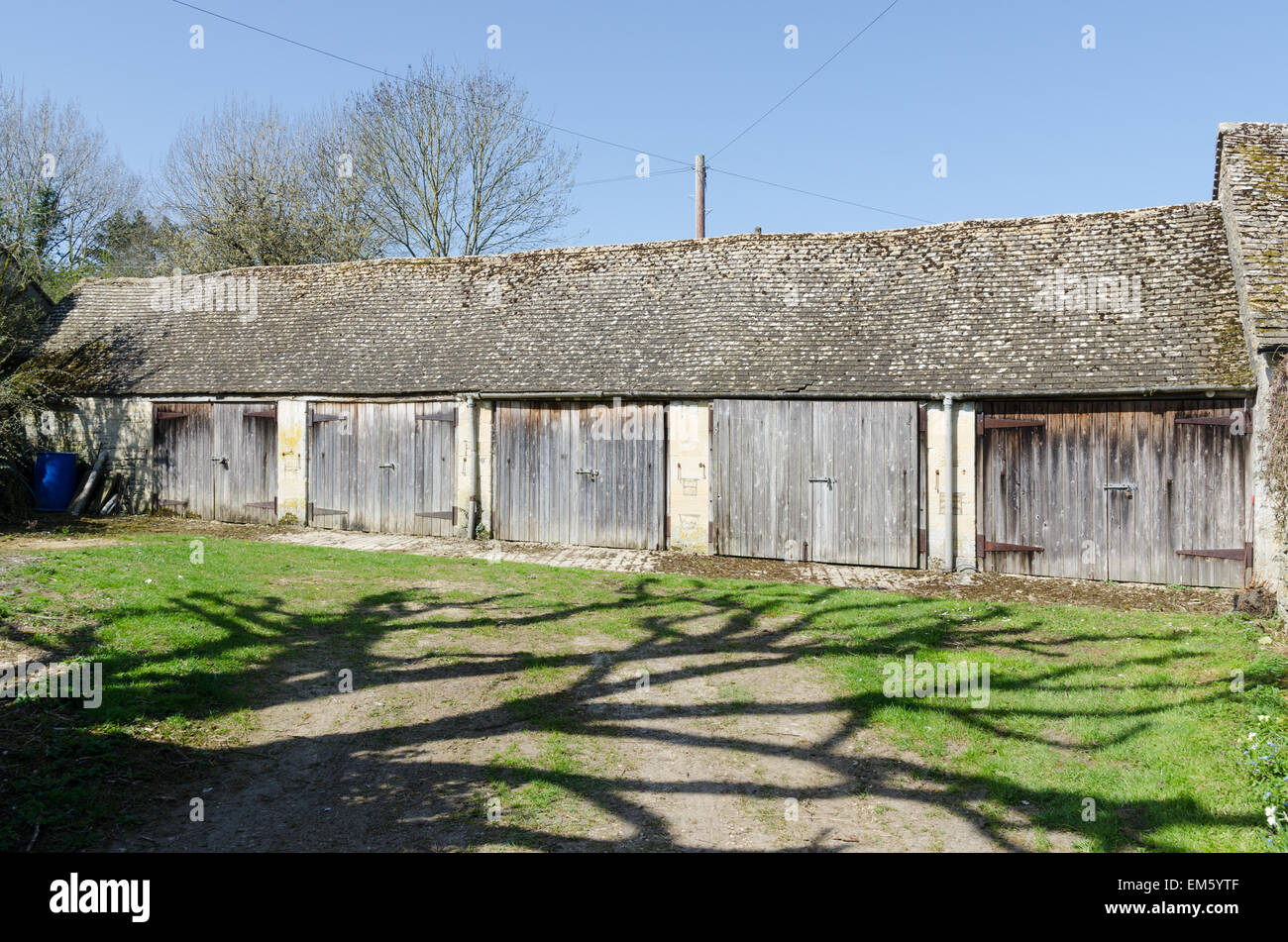 Old stone farm buildings in the Cotswold village of Bibury near